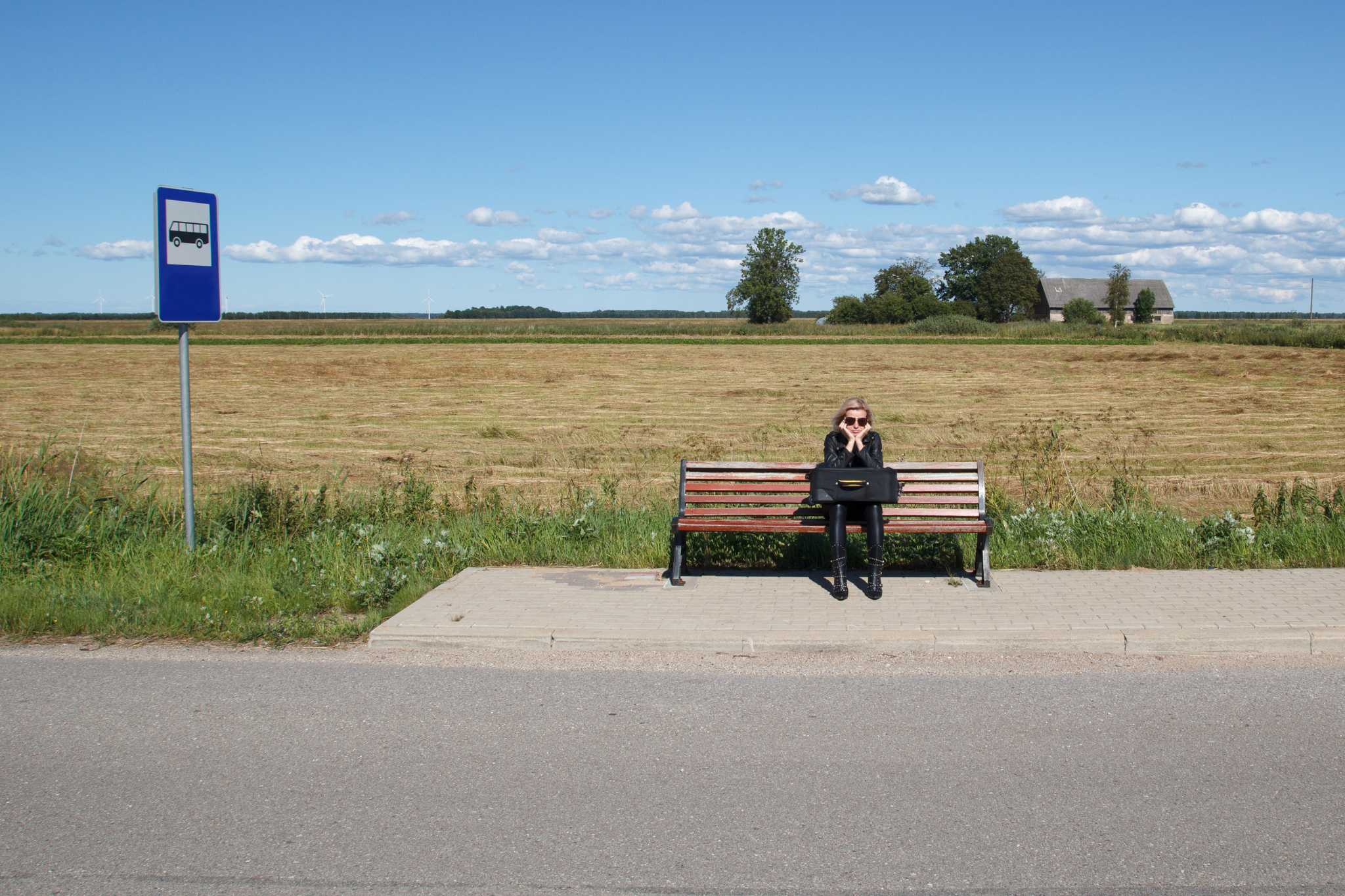 Foto zum Projekt MobiDig; einsame Frau, die auf einen Bus im ländlichen Gebiet wartet